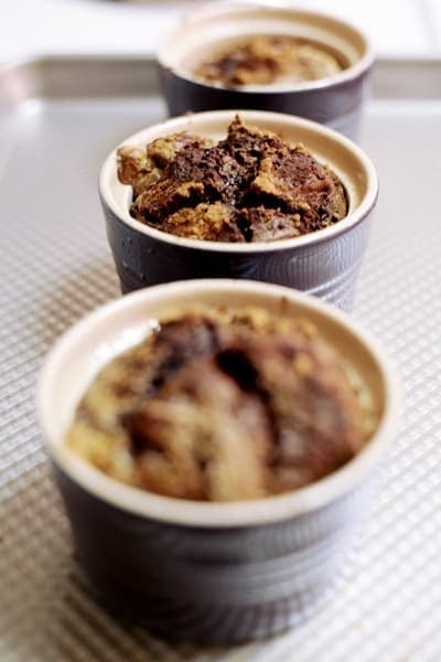 Three souffles in purple tins are shown on a baking sheet