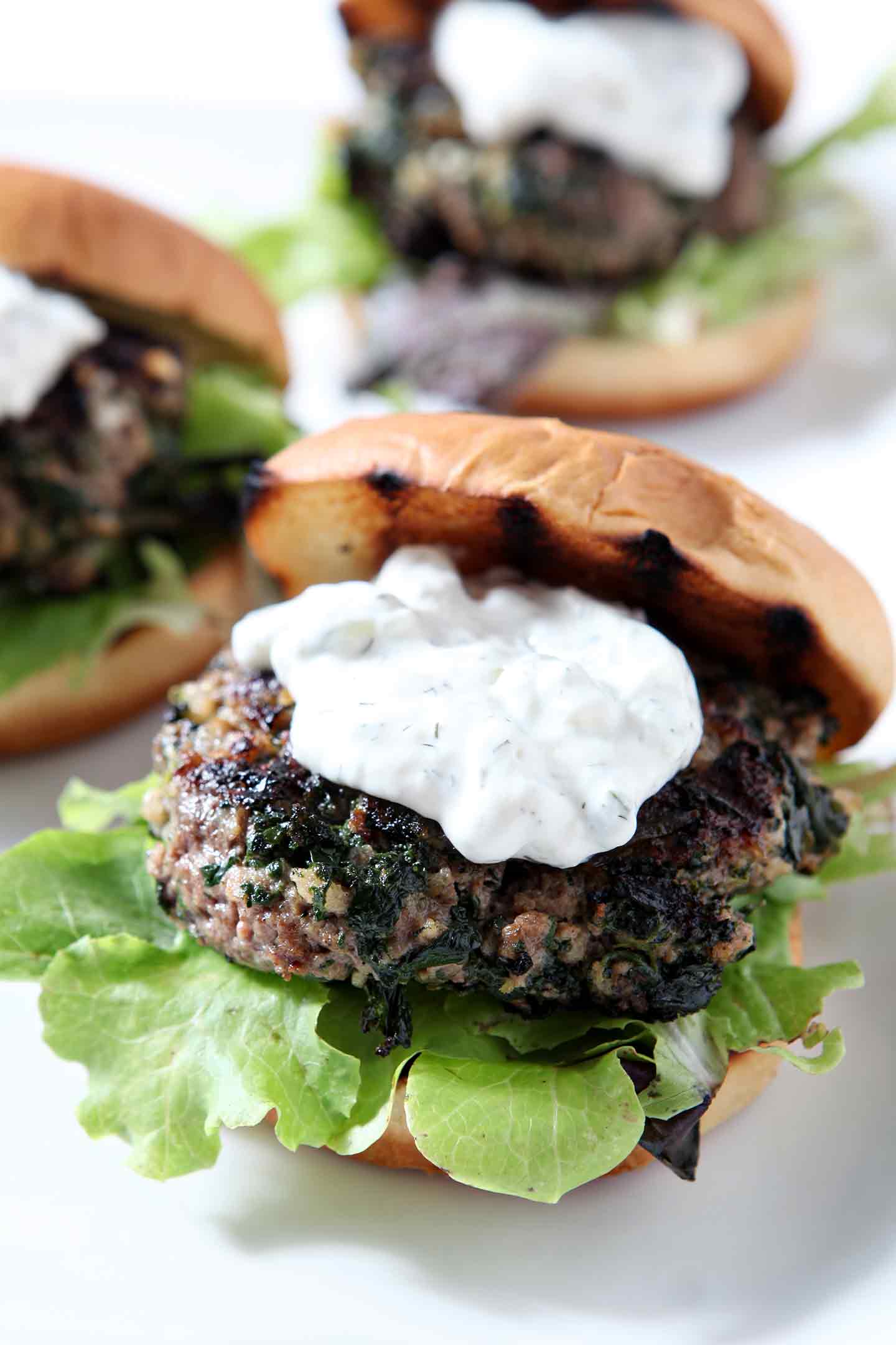 Close up of a burger, topped with tzatziki sauce