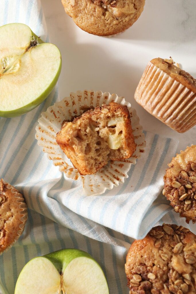 A bitten-into apple muffin on marble