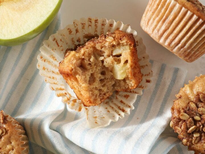 A bitten-into apple muffin on marble