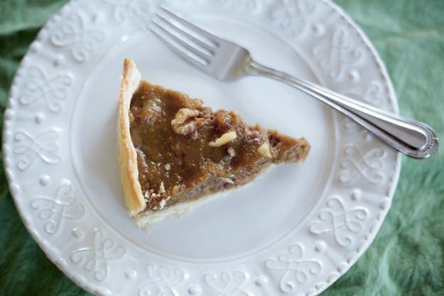 Overhead close up view showing slice of pie on white plate with a fork