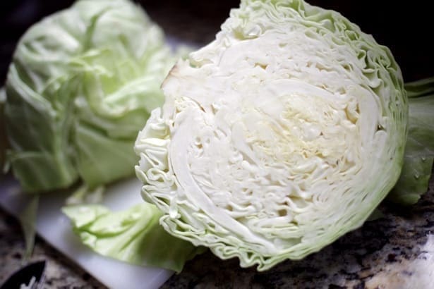 A halved cabbage on a granite countertop