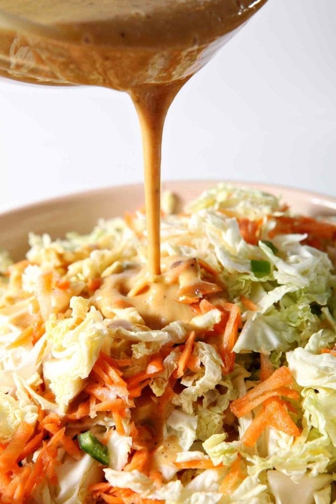 Honey Mustard Dressing pours on top of cabbage