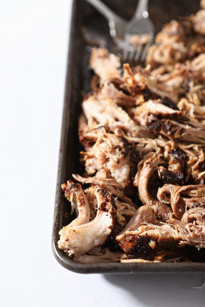 A tray of slow cooker bbq pulled pork with forks