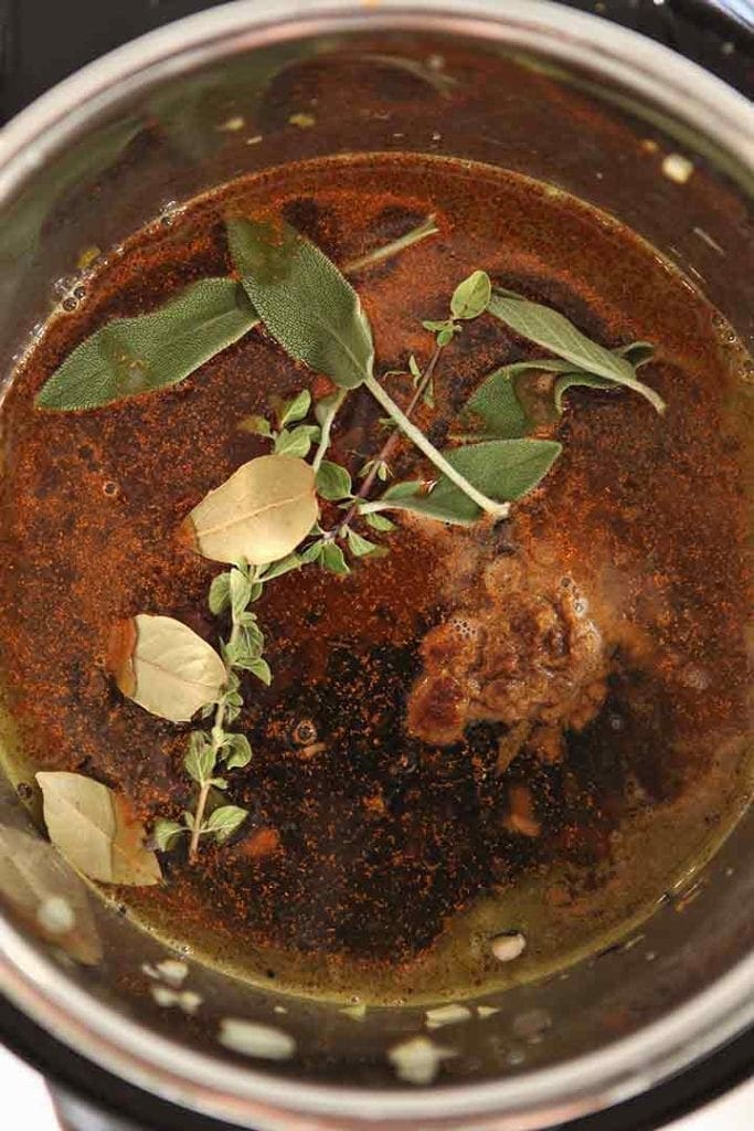 Beans are shown in the pot with all the seasonings