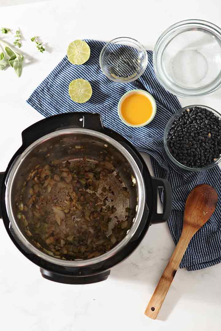 The sauteed veggies are shown in the Instant Pot, surrounded by the other ingredients yet to be added