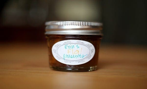 A small mason jar, labeled Erin's Fig Preserves, sits on a wooden table