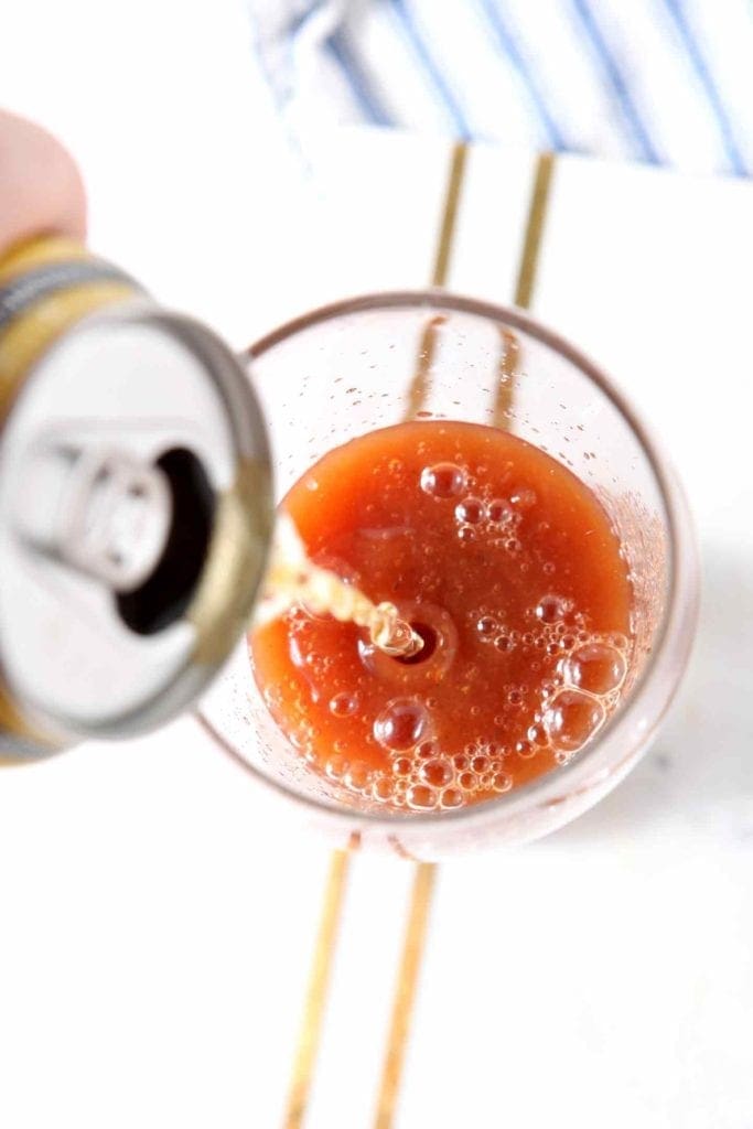 A beer pours into bloody mary mix