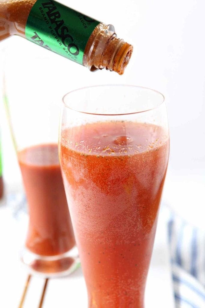 Tabasco sauce sprinkles into a glass of red beer