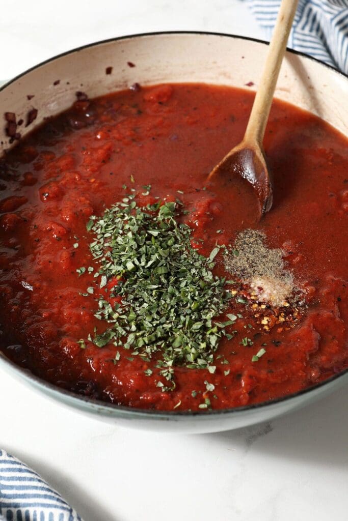 Tomato sauce with fresh herbs and spices in a pan