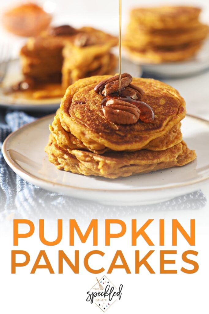 Syrup drizzles on top of a stack of Buttermilk Pumpkin Spice Pancakes with pecans on top with the text 'pumpkin pancakes'