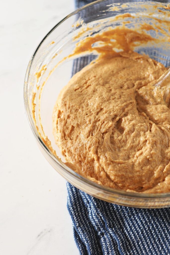 The final Pumpkin Spice Pancake batter in a bowl on a blue striped towel on marble