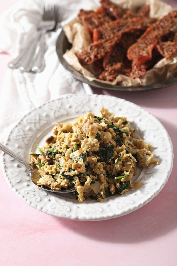 A plate holds a large serving of Scrambled Eggs with Spinach, mushrooms and onions