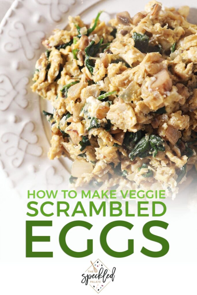 Closeup of a plate holding scrambled eggs with spinach, mushrooms and onions with the text 'how to make veggie scrambled eggs'