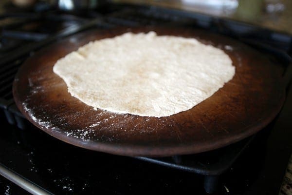 Pizza dough on a pizza stone on the stovetop