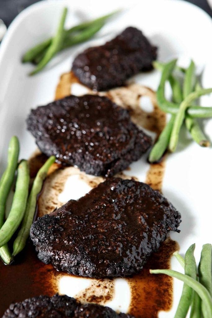 bakes steak with green beans on a white plate