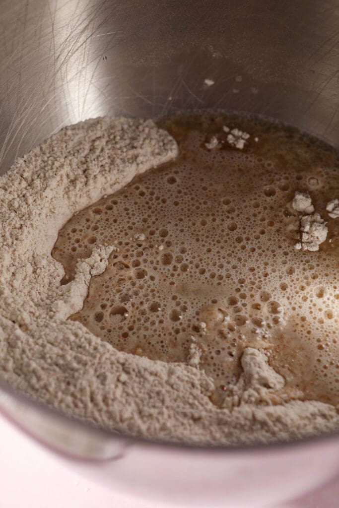 Pizza ingredients in the bowl of a stand mixer before mixing