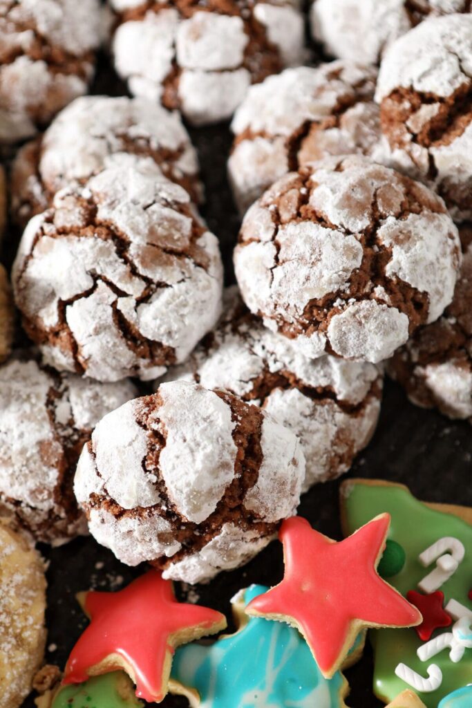 Stacked crinkle cookies on a sheet pan with other cookies