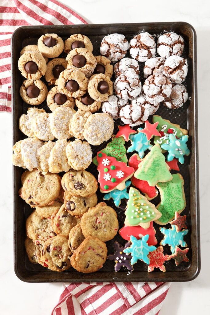 A tray of cookies with chocolate crinkles, potato chip cookies, chocolte chip cookies, sugar cookies and more