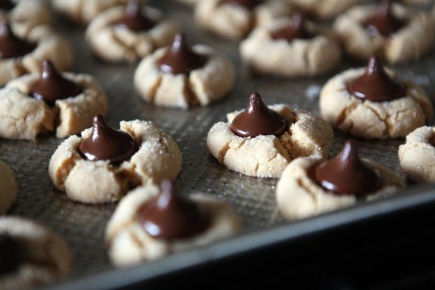 A baking sheet full of hot Peanut Blossoms with melty chocolate kisses