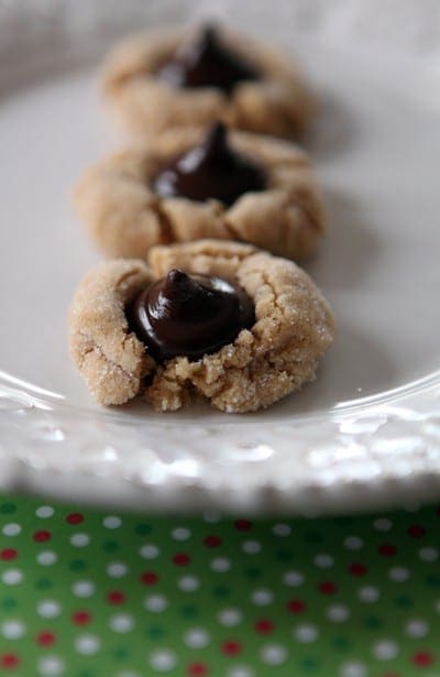 Three Peanut Blossom Cookies on a white plate on a decorative red, white and red polka dot placemat