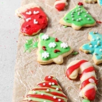 Iced and decorated All-Butter Tea Cake Cookies dry on a piece of parchment paper