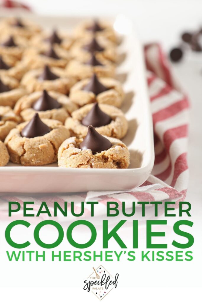 A tray of Dark Chocolate Peanut Blossom Cookies on top of a red and white striped towel with the text 'peanut butter cookies with hershey's kisses'