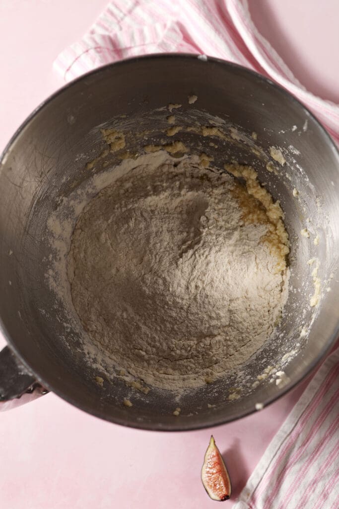 a flour mixture sits on top of wet ingredients in a metal bowl