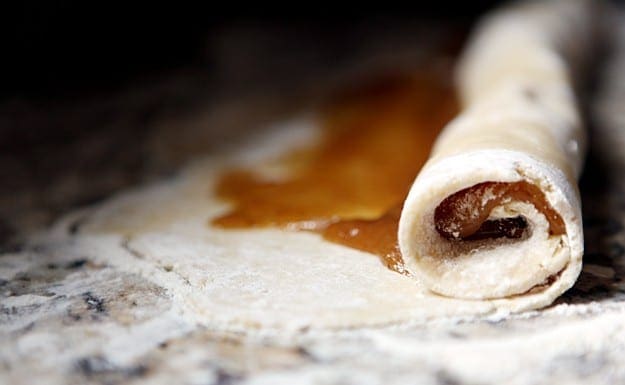 Close up of rolled pinwheel on floured granite countertop 