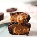 A halved homemade peanut butter cup cut on a turquoise and white plate