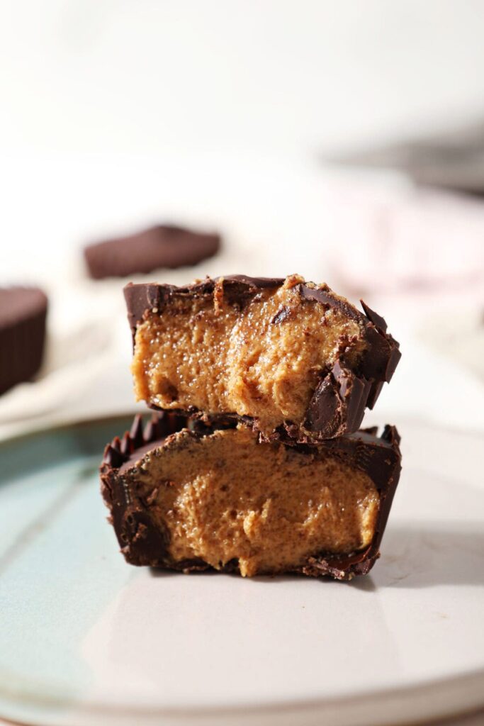 A halved homemade peanut butter cup cut on a turquoise and white plate