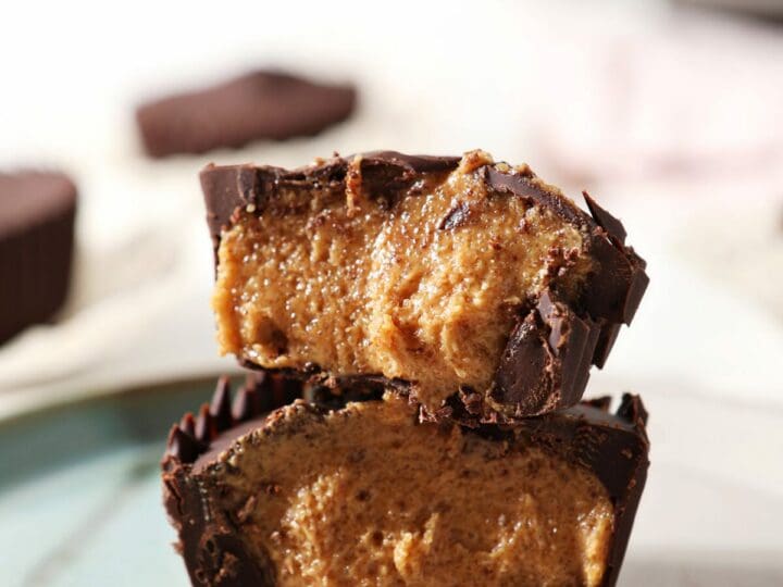 A halved homemade peanut butter cup cut on a turquoise and white plate