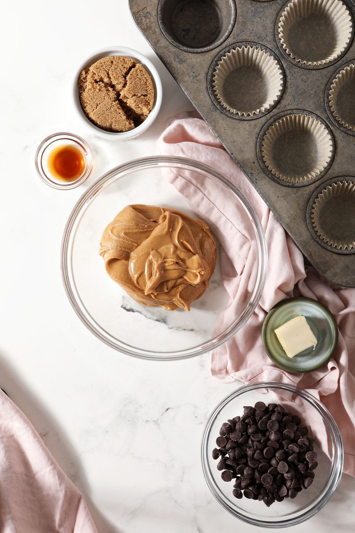 Ingredients to make homemade peanut butter cups in bowls on marble
