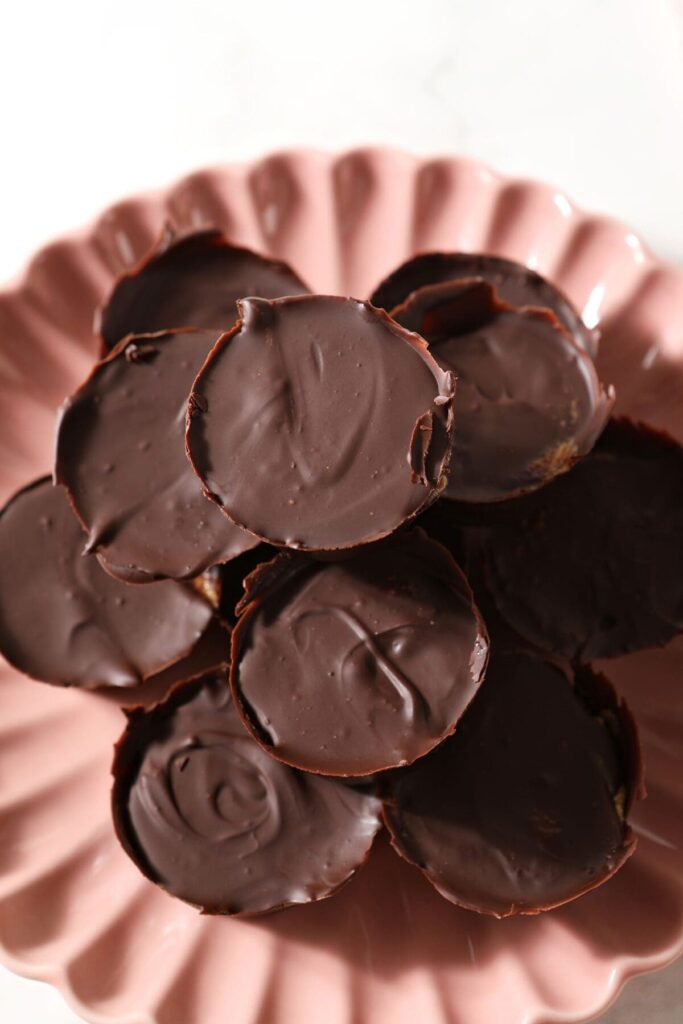 Several miniature peanut butter cups on a pink plate