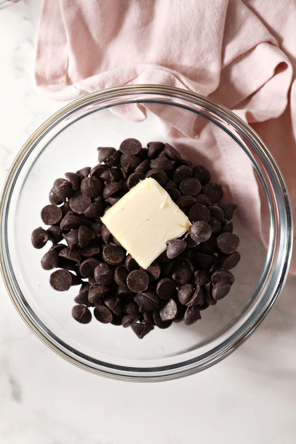 Butter and chocolate chips in a bowl with a pink linen