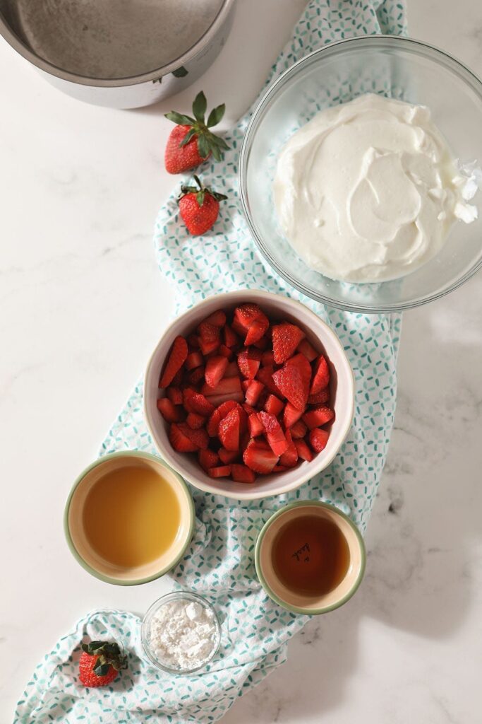 Ingredients for homemade pudding sit on a turquoise towel in bowls on top of a marble countertop