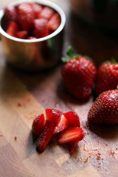 Close up of chopped strawberries on a cutting board