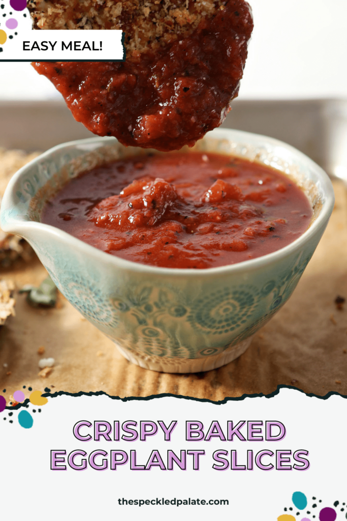 A crunchy eggplant medallion dips into a bowl of marinara sauce on a sheet pan with the text Crispy Baked Eggplant Slices