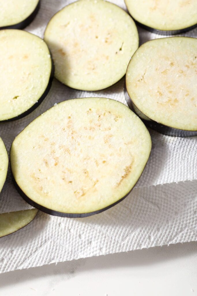 Slices of raw eggplant on a paper towel