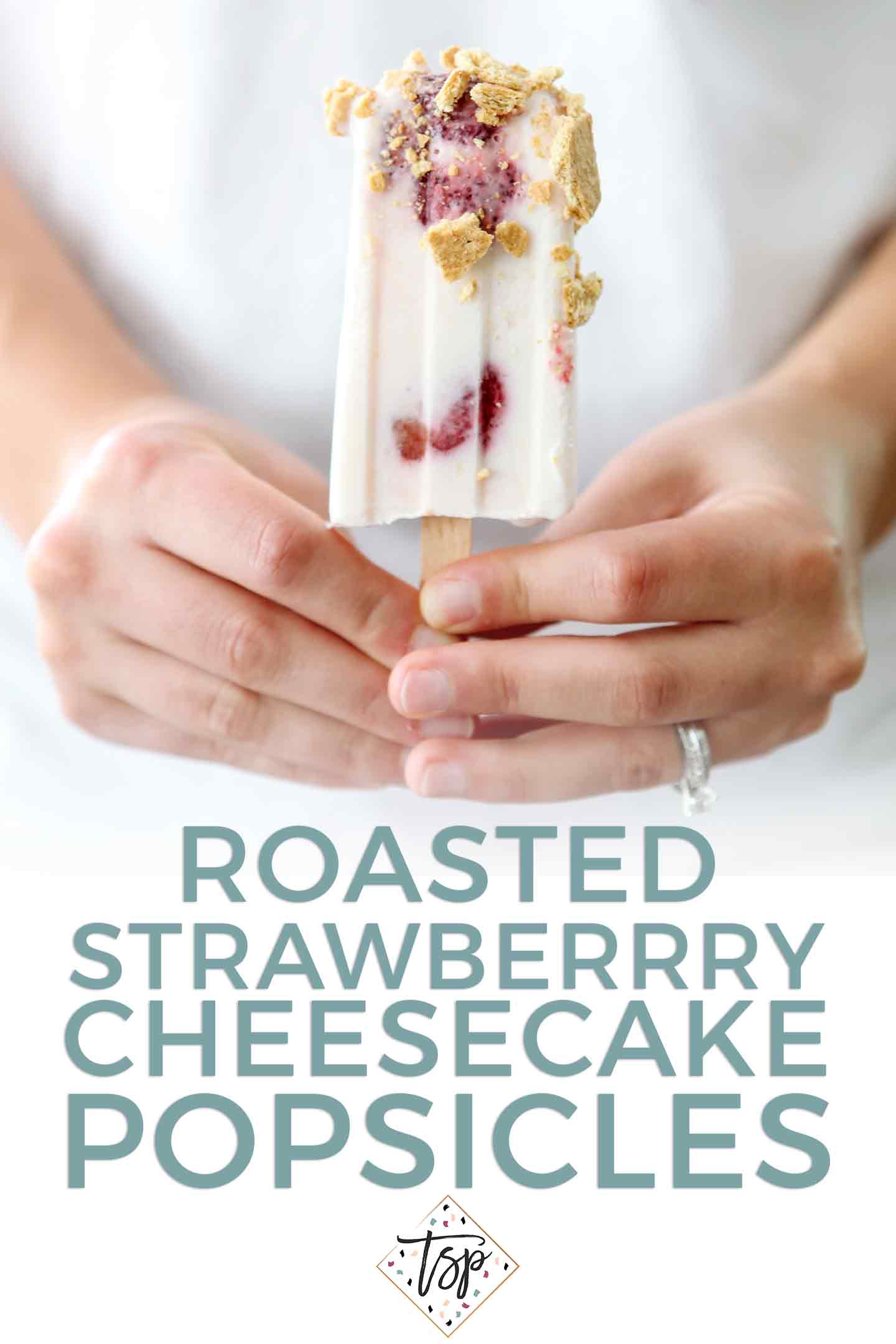 Pinterest graphic for Roasted Strawberry Cheesecake Pops, featuring a woman holding one of the popsicles in hand