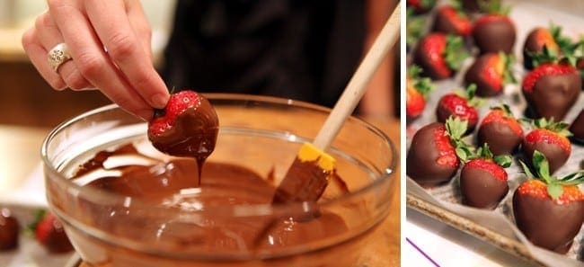 Chocolate covered strawberries being hand dipped in chocolate and on laying on baking sheet 