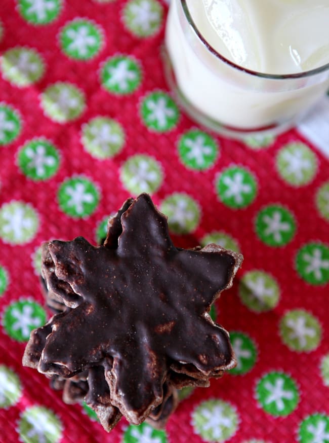 Overhead close up of stacked cocoa wafers on holiday linens with glass of milk 