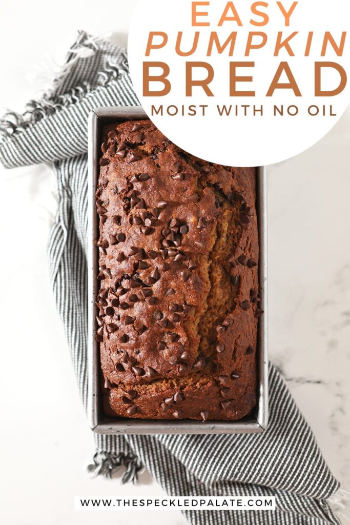 Overhead of a chocolate chip-studded loaf in a metal tin on top of a gray towel with the text 'easy pumpkin bread. moist with no oil'