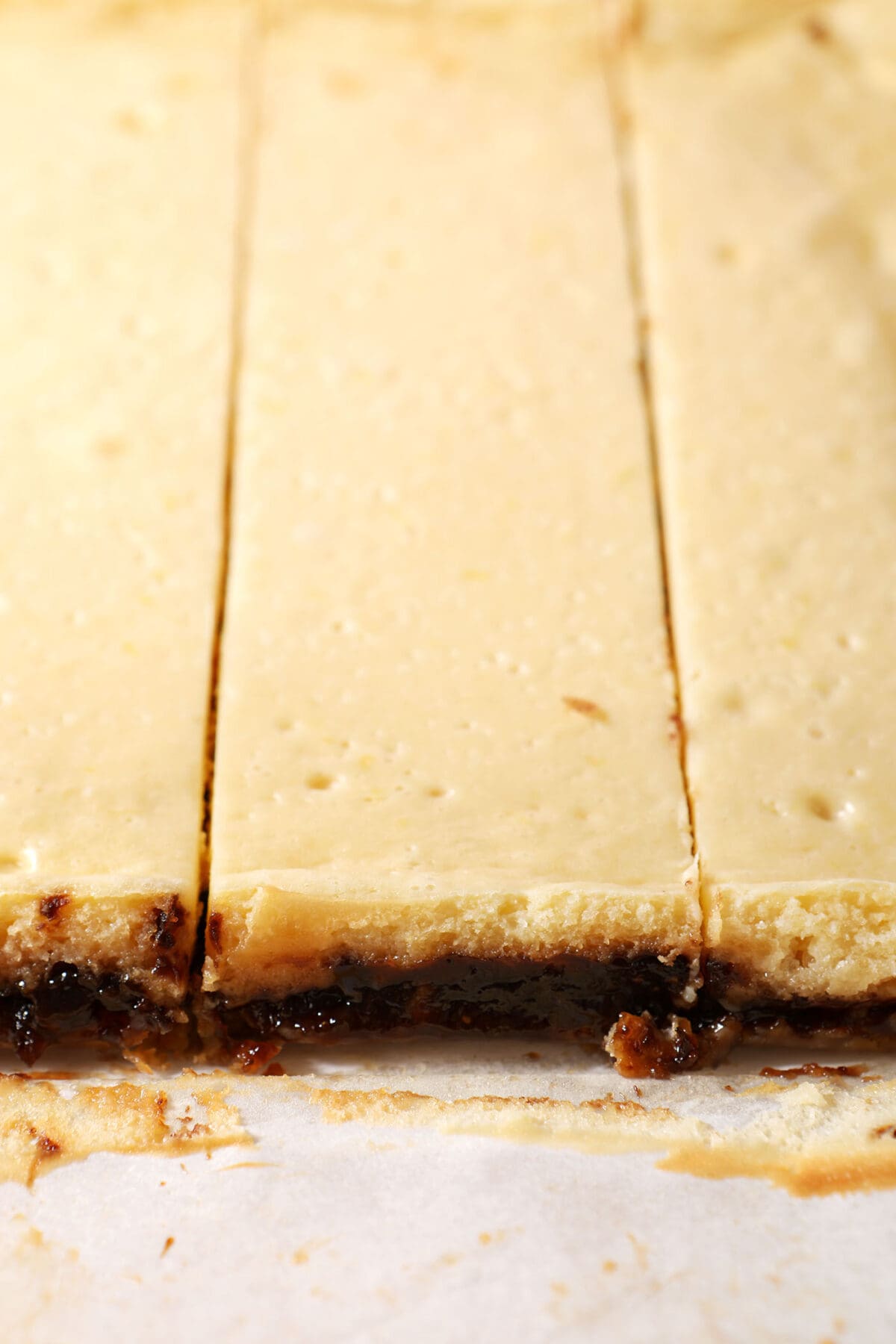 close up of sliced lemon fig cheesecake bars on parchment