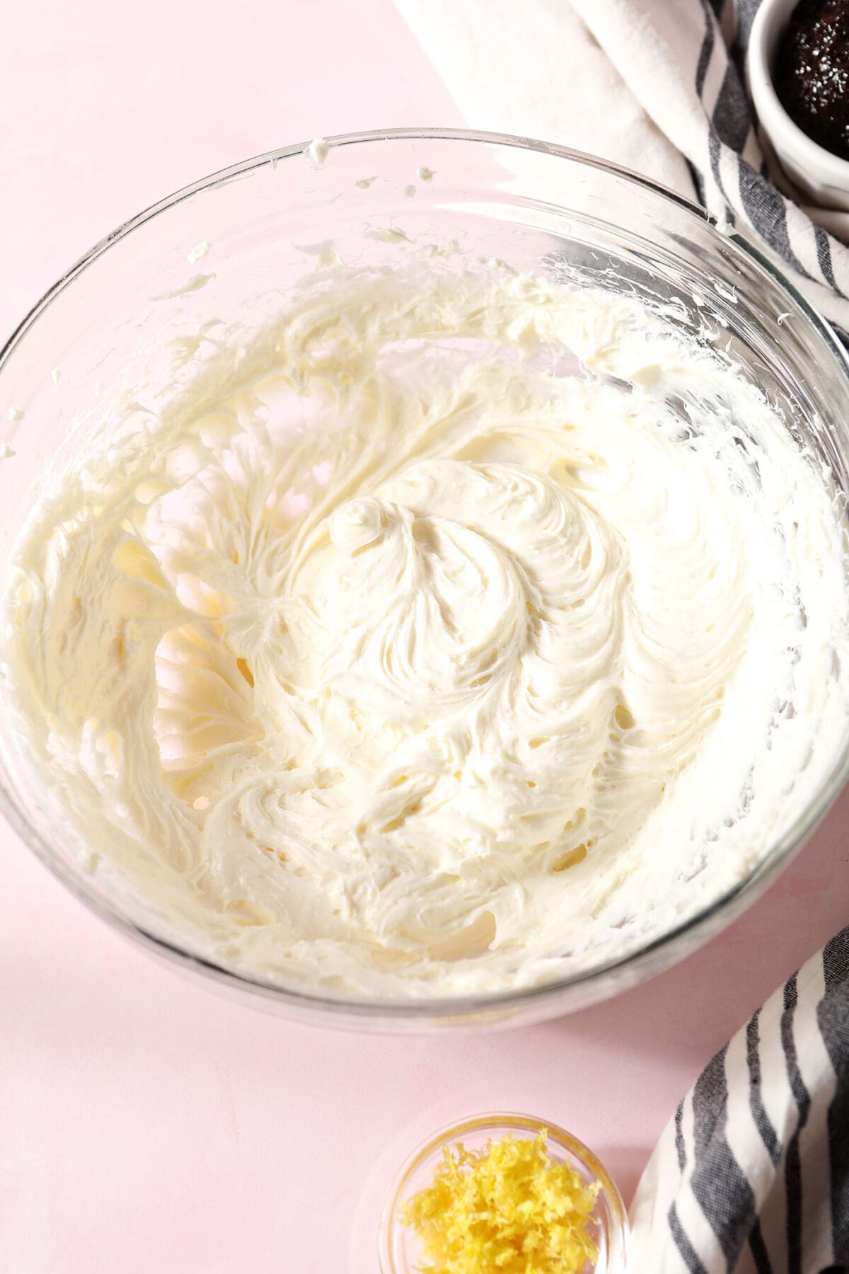 the combined cream cheese and sugar in a bowl on a pink surface