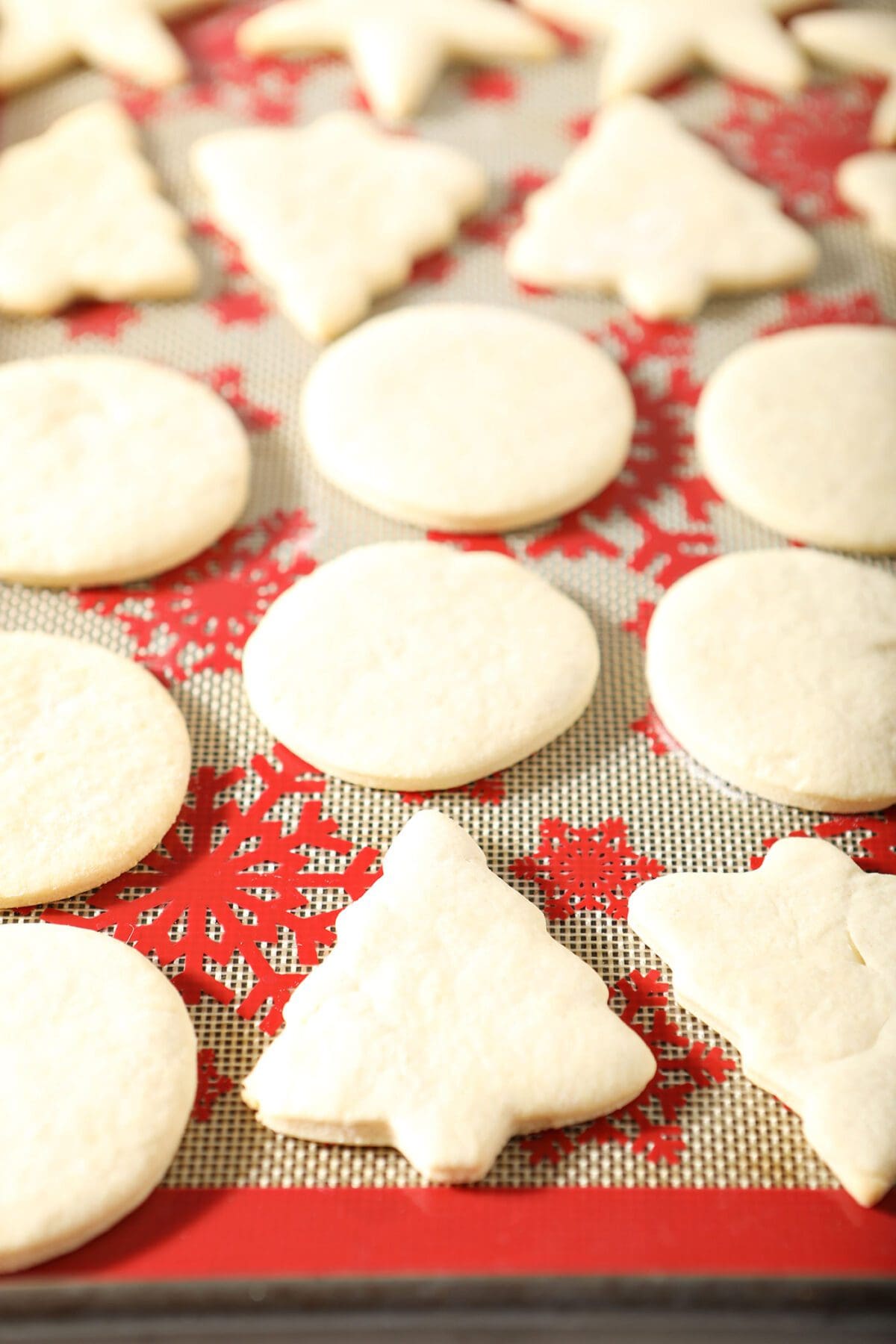 Baked cut out sugar cookies on a red festive silpat