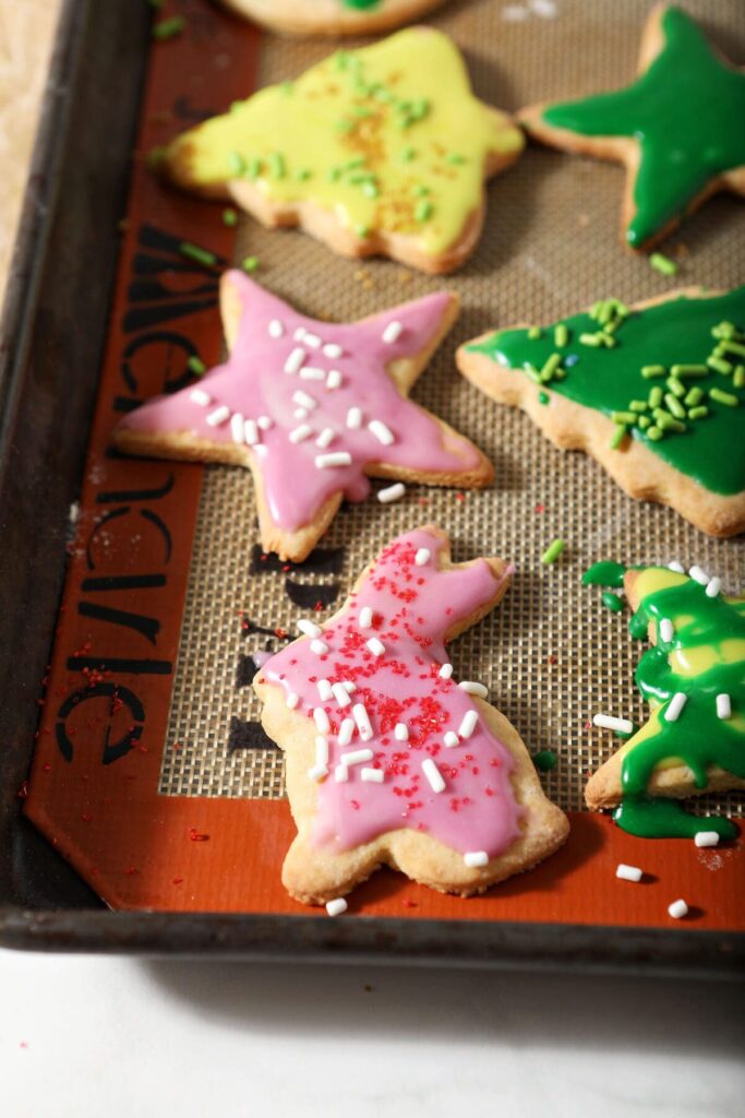 Close up of a bunny-shaped cookie frosted in pink icing with other shapes of cookies near it