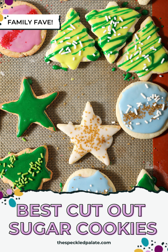 Close up of colorful iced sugar cookies on a silpat-lined sheet pan with the text BEST Cut Out Sugar Cookies