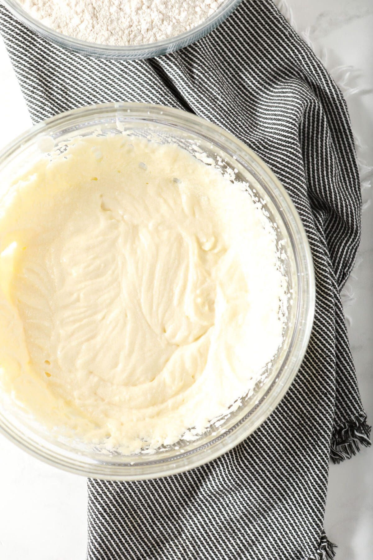 The creamy wet ingredients in a bowl on a gray striped towel