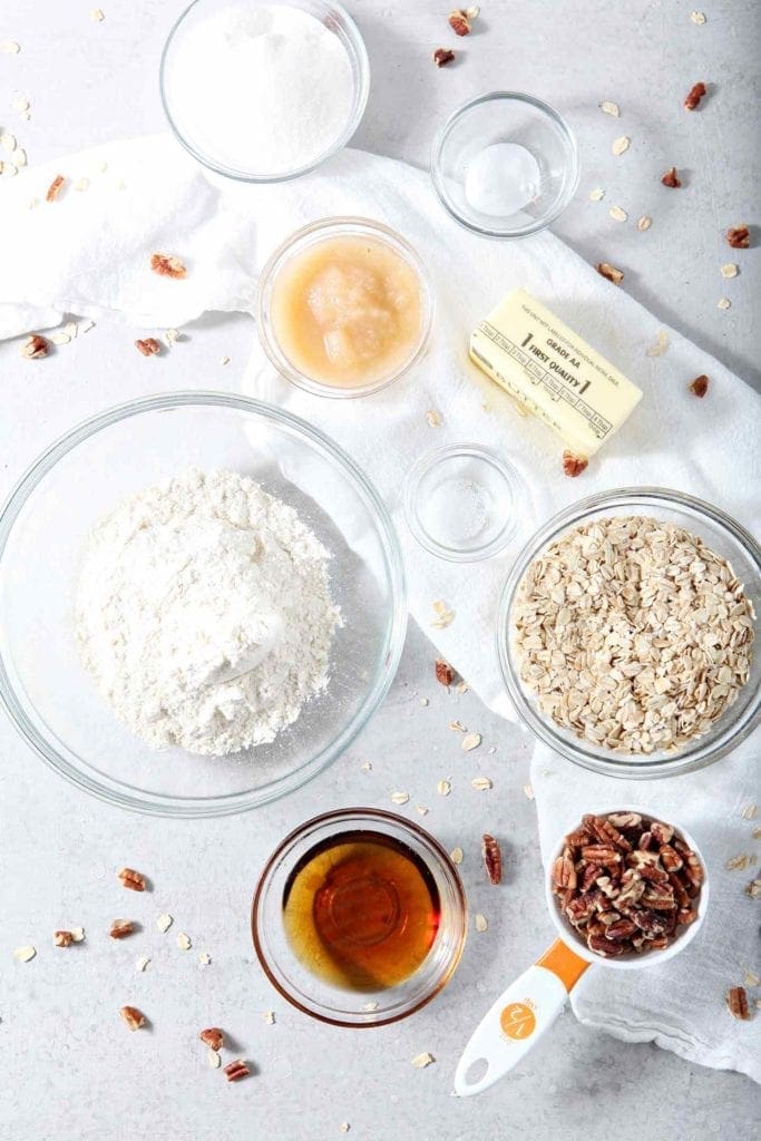 Ingredients for Quebec Maple Pecan Drop Cookies are laid out on a grey backdrop